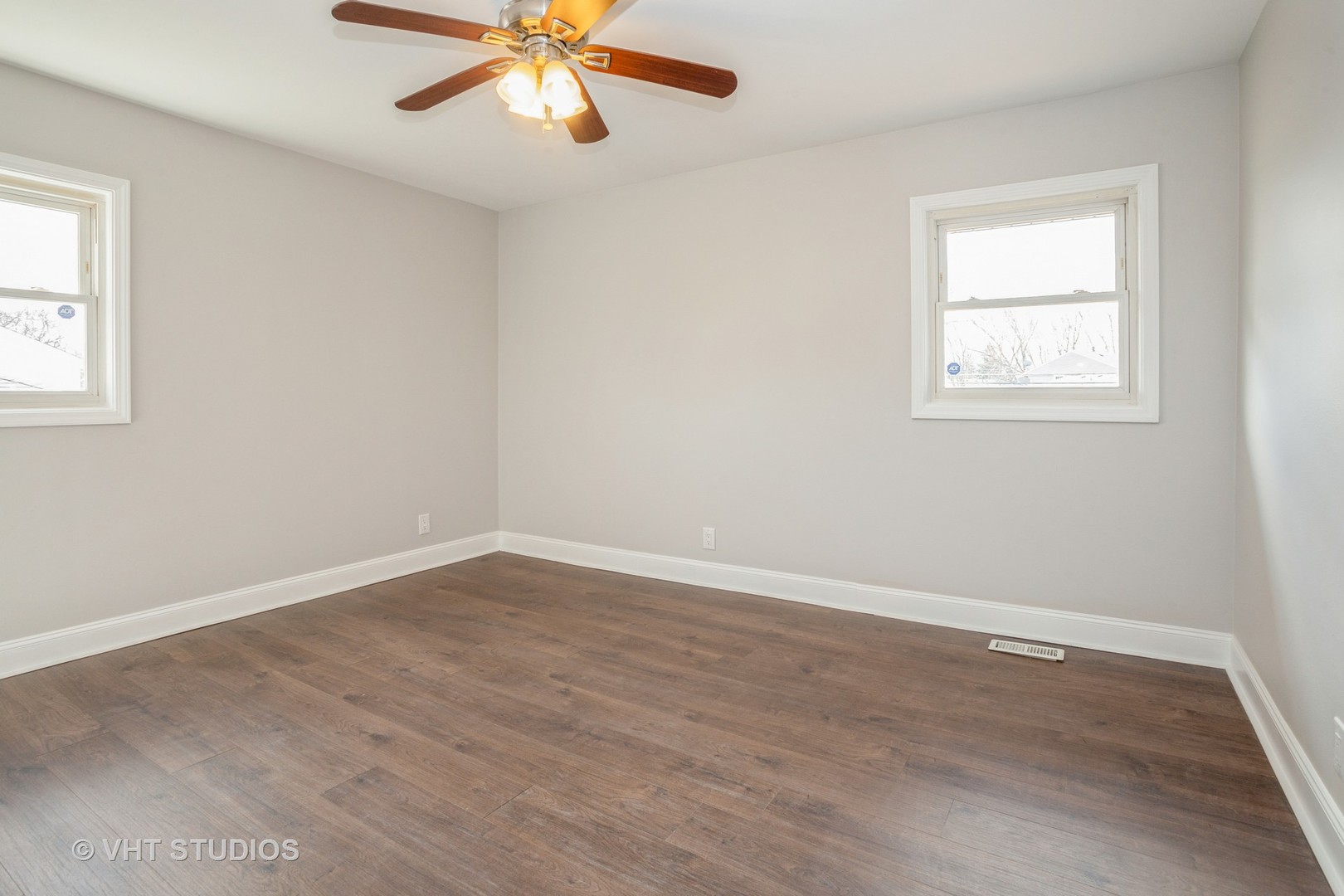 326 Brunswick Court Streamwood, IL 60107 - Photo 6 of 10 an empty room with wooden floor chandelier fan and windows