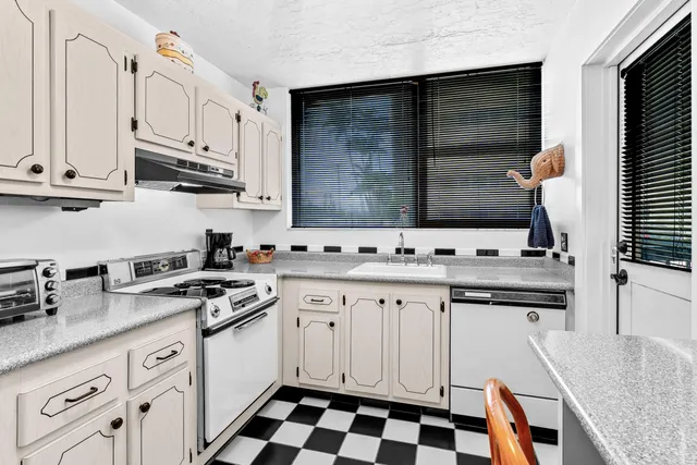 a kitchen with stainless steel appliances granite countertop a sink stove and cabinets