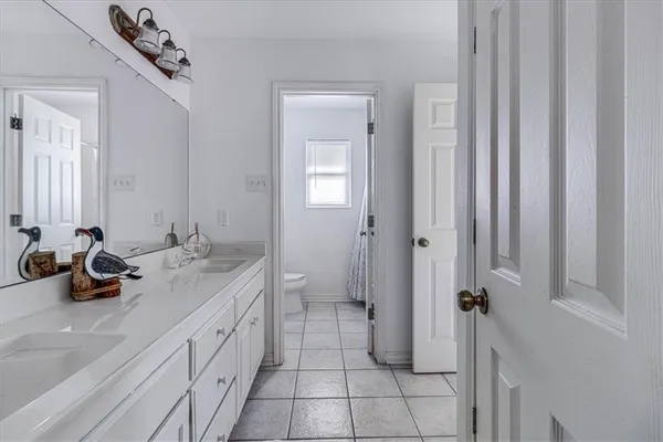 a spacious bathroom with a double vanity sink a mirror and a shower