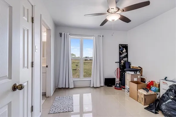 a view of a livingroom with lounge chair and windows