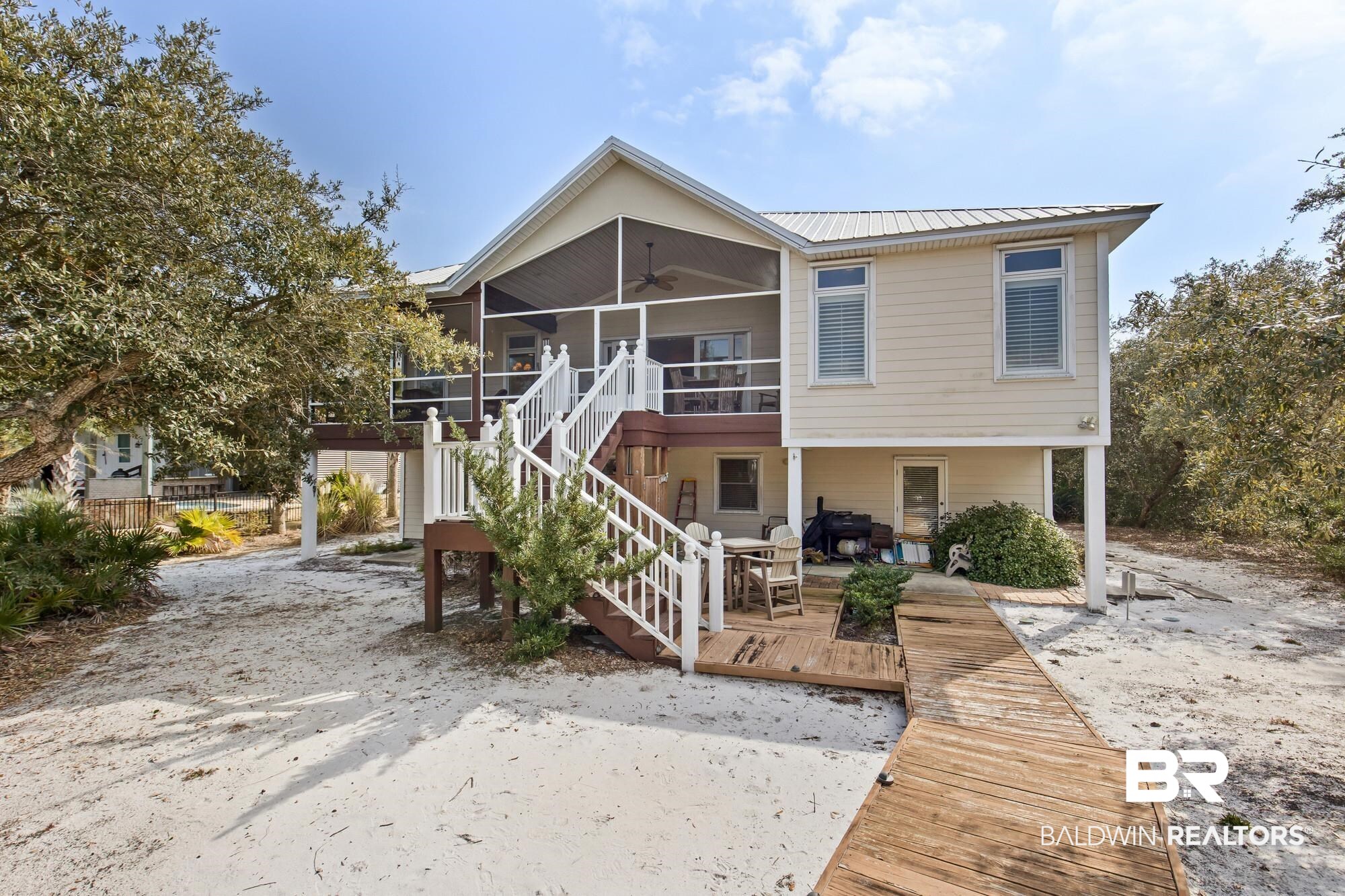 32191 River Road Orange Beach, AL 36561 - Photo 32 of 46 Back of property featuring a ceiling fan, a deck, a metal roof, and a sunroom