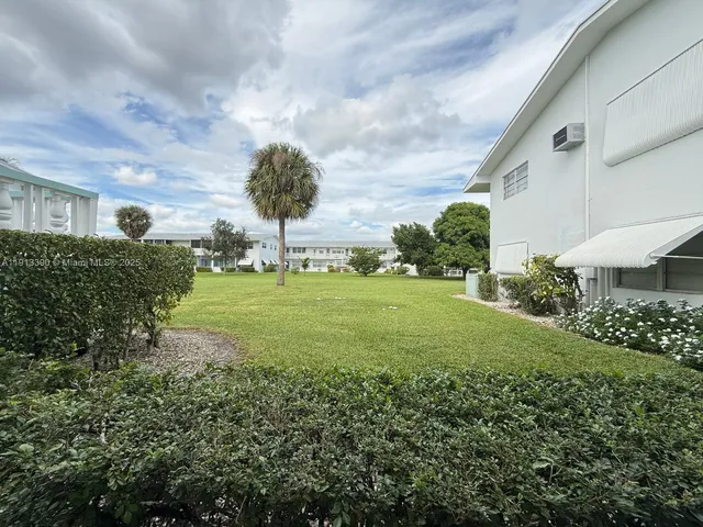 a view of a garden with plants and a bench