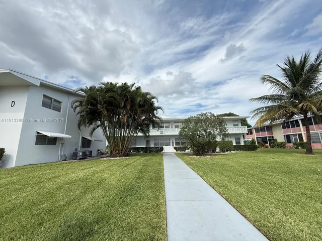 a view of a house with a big yard and potted plants