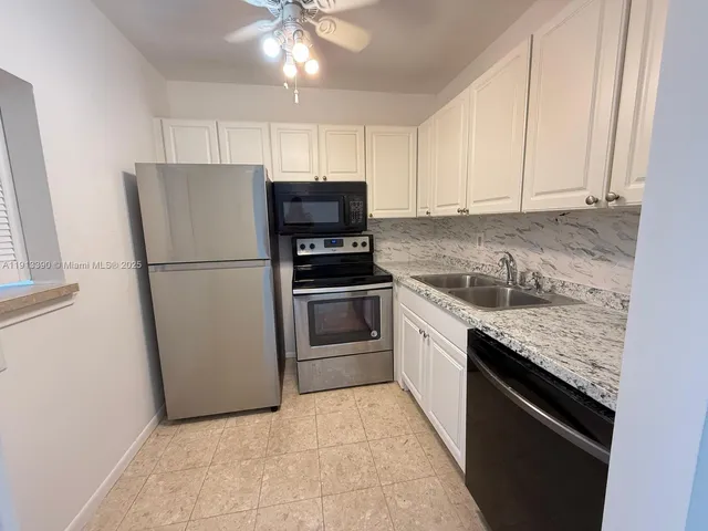 a kitchen with granite countertop a refrigerator oven a sink and dishwasher