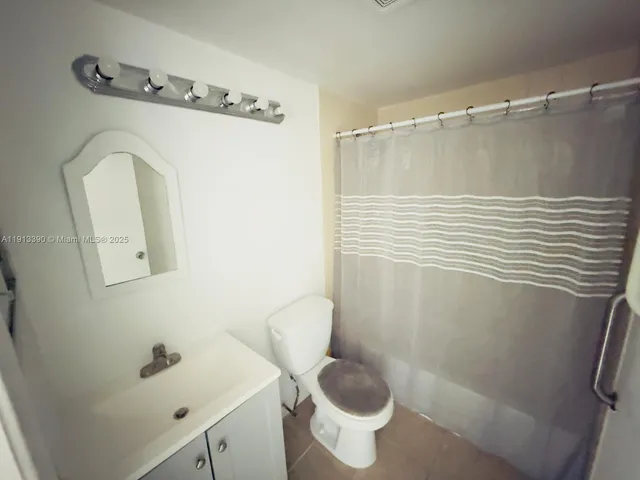 a bathroom with a shower a toilet and sink