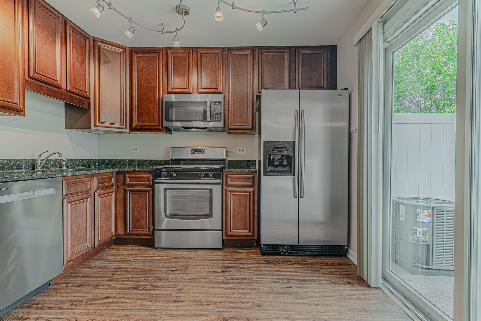 184 Rodenburg Road Roselle, IL 60172 - Photo 7 of 29 a kitchen with a refrigerator stove and wooden cabinets