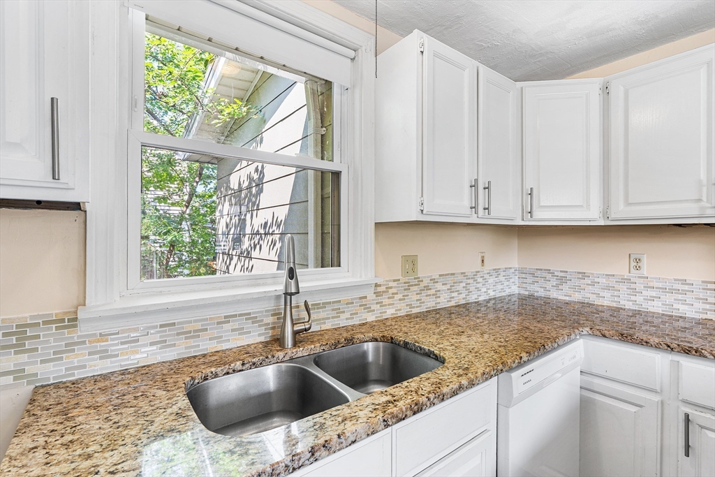 13 Maple Street Easthampton, MA 01027 - Photo 11 of 36 a kitchen with granite countertop a sink and a window