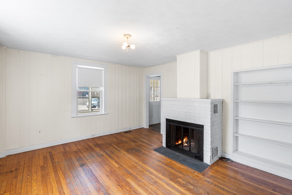 13 Maple Street Easthampton, MA 01027 - Photo 4 of 36 a view of an empty room with wooden floor fireplace and a window