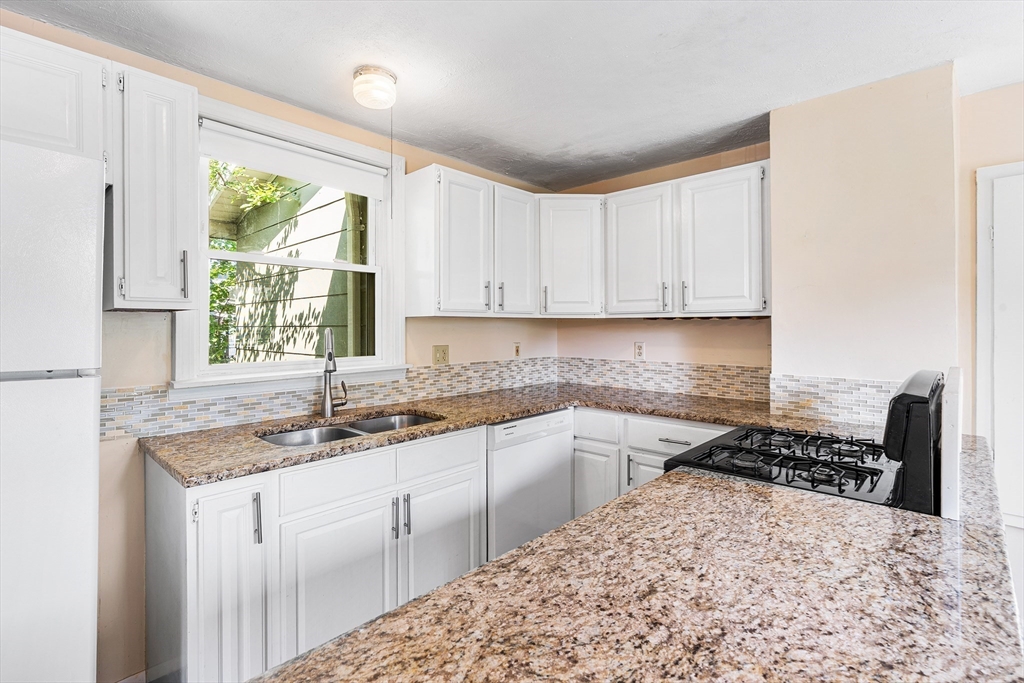 13 Maple Street Easthampton, MA 01027 - Photo 9 of 36 a kitchen with a stove sink and cabinets