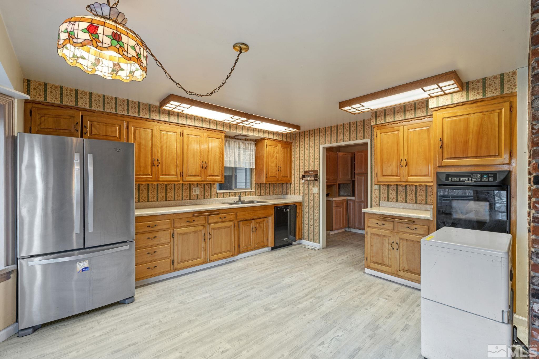 1631 Eli Drive Reno, NV 89511 - Photo 17 of 40 a kitchen with granite countertop stainless steel appliances a refrigerator and a stove top oven