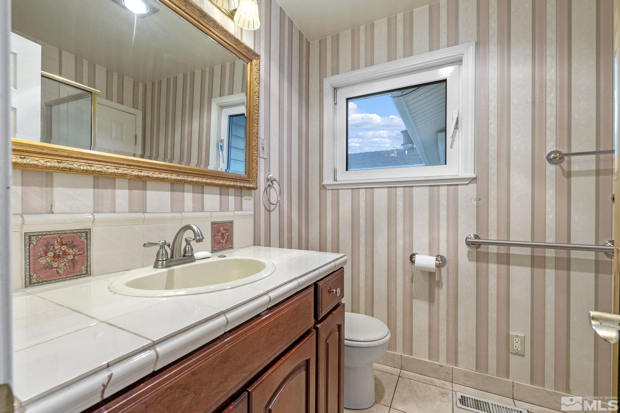 1631 Eli Drive Reno, NV 89511 - Photo 21 of 40 a bathroom with a sink a toilet and a mirror