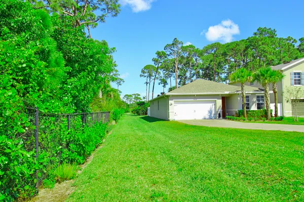 a view of a house with a back yard and a garden