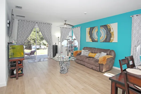 a living room with furniture and a wooden floor