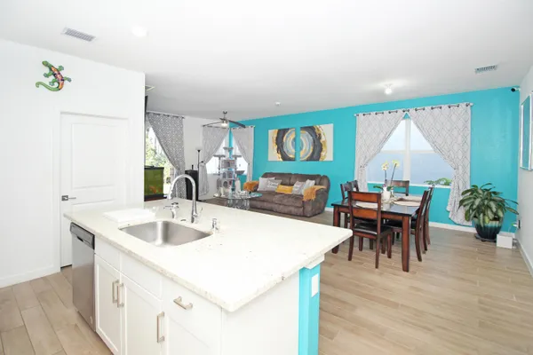 a kitchen with kitchen island granite countertop a sink a stove and refrigerator