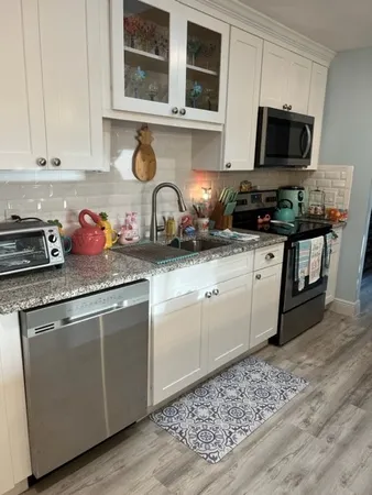 a kitchen with stainless steel appliances granite countertop a stove a sink and a microwave