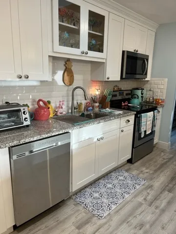 a kitchen with stainless steel appliances granite countertop a stove a sink and a microwave