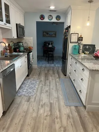 a kitchen with granite countertop a sink stove and cabinets