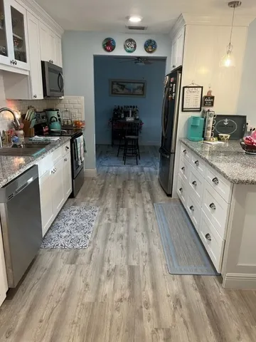 a kitchen with granite countertop a sink stove and cabinets