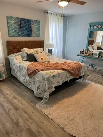 a bedroom with a bed table flowerpot and window