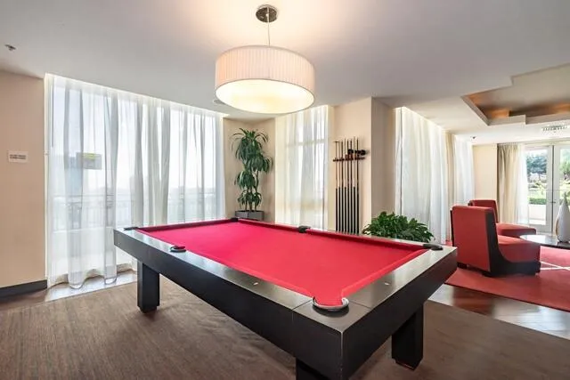 a room with pool table and windows