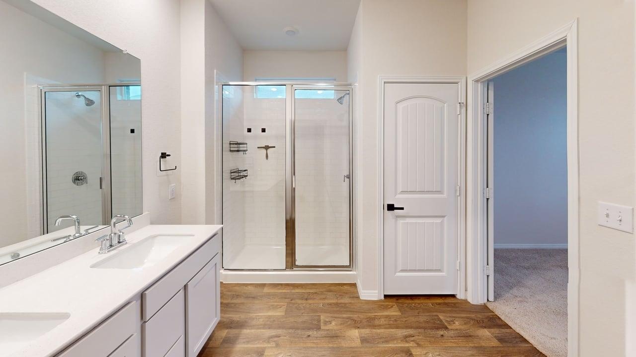 245 Brooklyn Drive Georgetown, TX 78626 - Photo 18 of 23 Bathroom with double vanity, a shower stall, and light wood-style floors