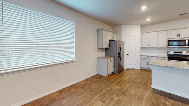 a kitchen with a refrigerator and a stove top oven