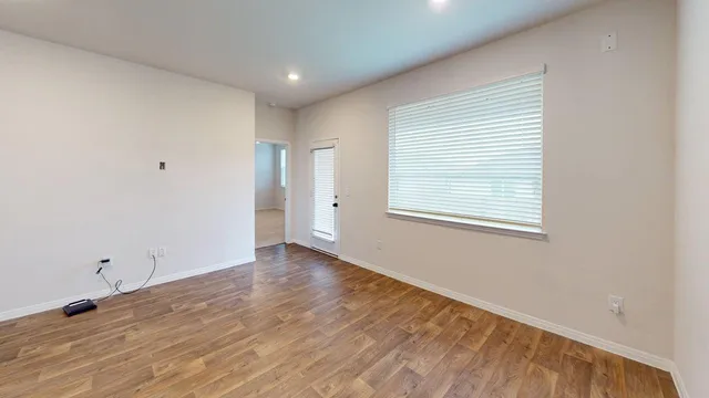 wooden floor in an empty room with a window