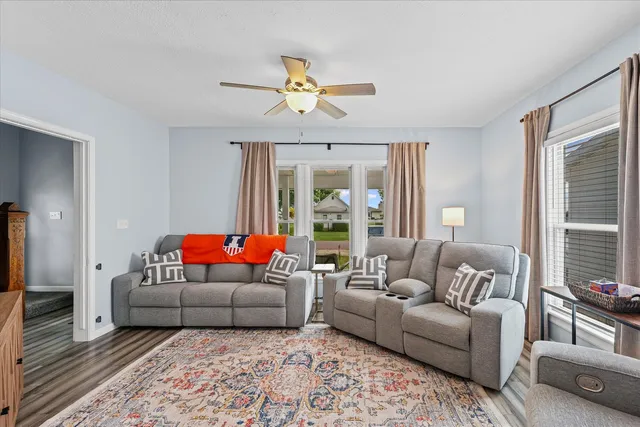 a living room with furniture ceiling fan and a flat screen tv