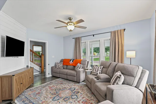 a living room with lots of books and a wooden floor