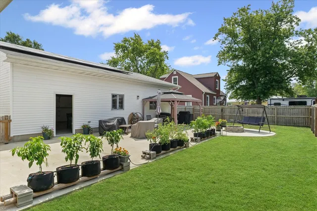 a view of a house with backyard sitting area and garden