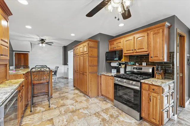 a kitchen with stainless steel appliances granite countertop a stove sink microwave and refrigerator