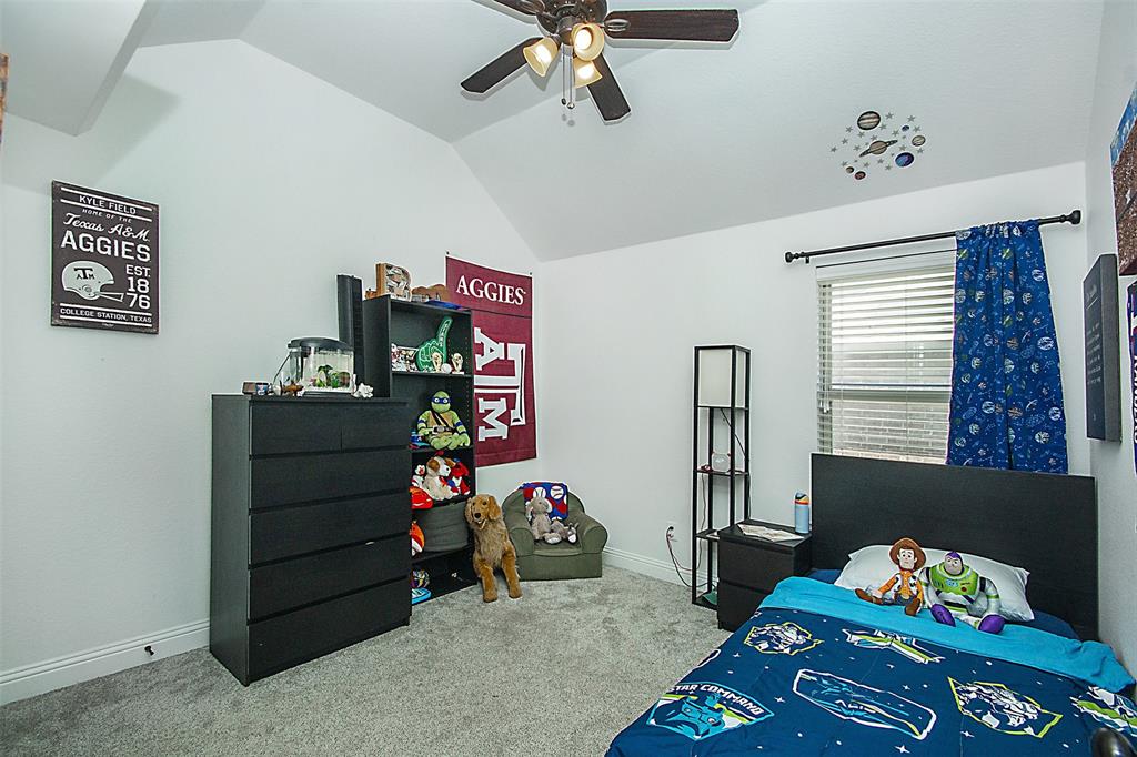 5809 Yellow Rose Court Midlothian, TX 76065 - Photo 20 of 33 Vaulted ceiling with a ceiling fan, light gray carpeting, and a window with blinds and blue curtains