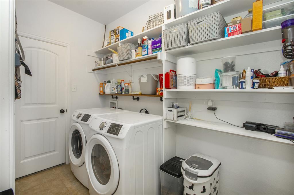 5809 Yellow Rose Court Midlothian, TX 76065 - Photo 22 of 33 Utility room featuring tile flooring, white shaker-style door, and extensive built-in shelving for storage