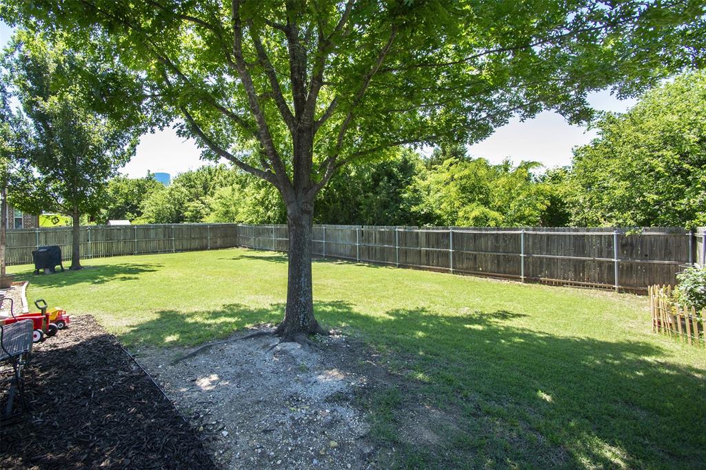 5809 Yellow Rose Court Midlothian, TX 76065 - Photo 24 of 33 Expansive backyard featuring a large tree, manicured lawn, and perimeter wood fencing