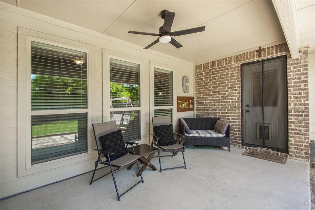 5809 Yellow Rose Court Midlothian, TX 76065 - Photo 27 of 33 Covered patio featuring a ceiling fan, concrete flooring, brick accent wall, and multiple windows