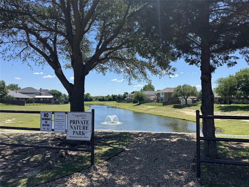 5809 Yellow Rose Court Midlothian, TX 76065 - Photo 33 of 33 Private nature park featuring a pond with a central fountain, surrounded by manicured green spaces and mature trees
