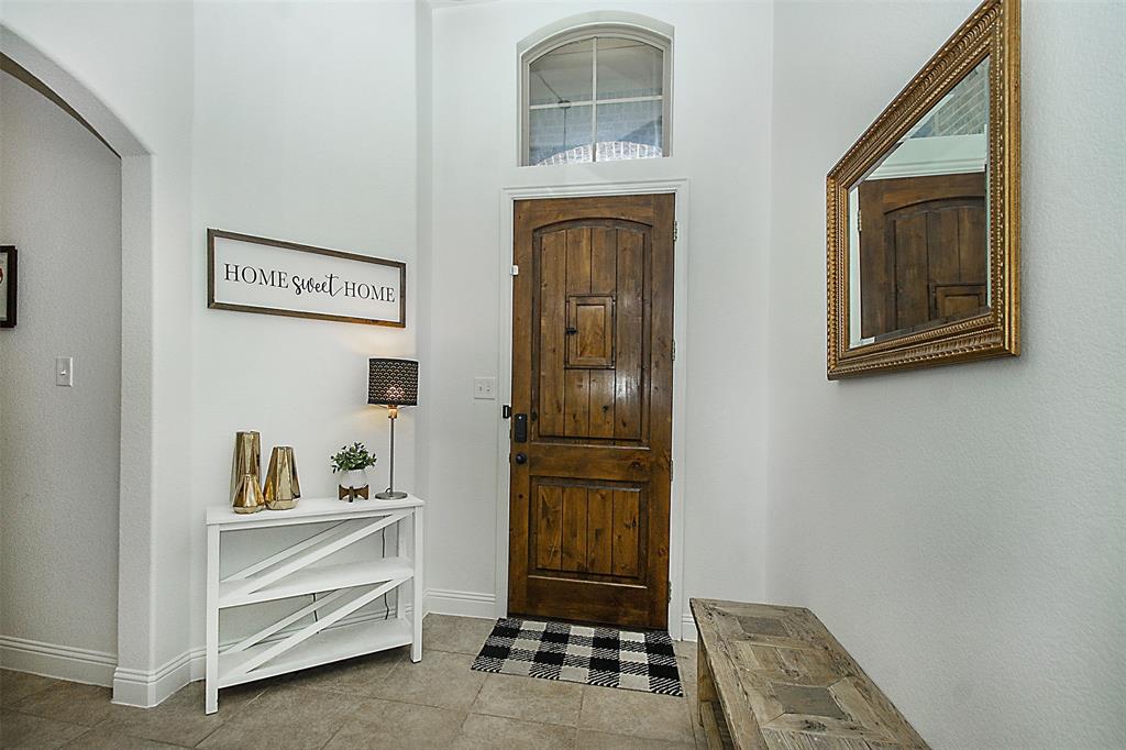 5809 Yellow Rose Court Midlothian, TX 76065 - Photo 7 of 33 Entryway featuring a wood plank door with an arched transom window, tiled flooring, and an arched doorway