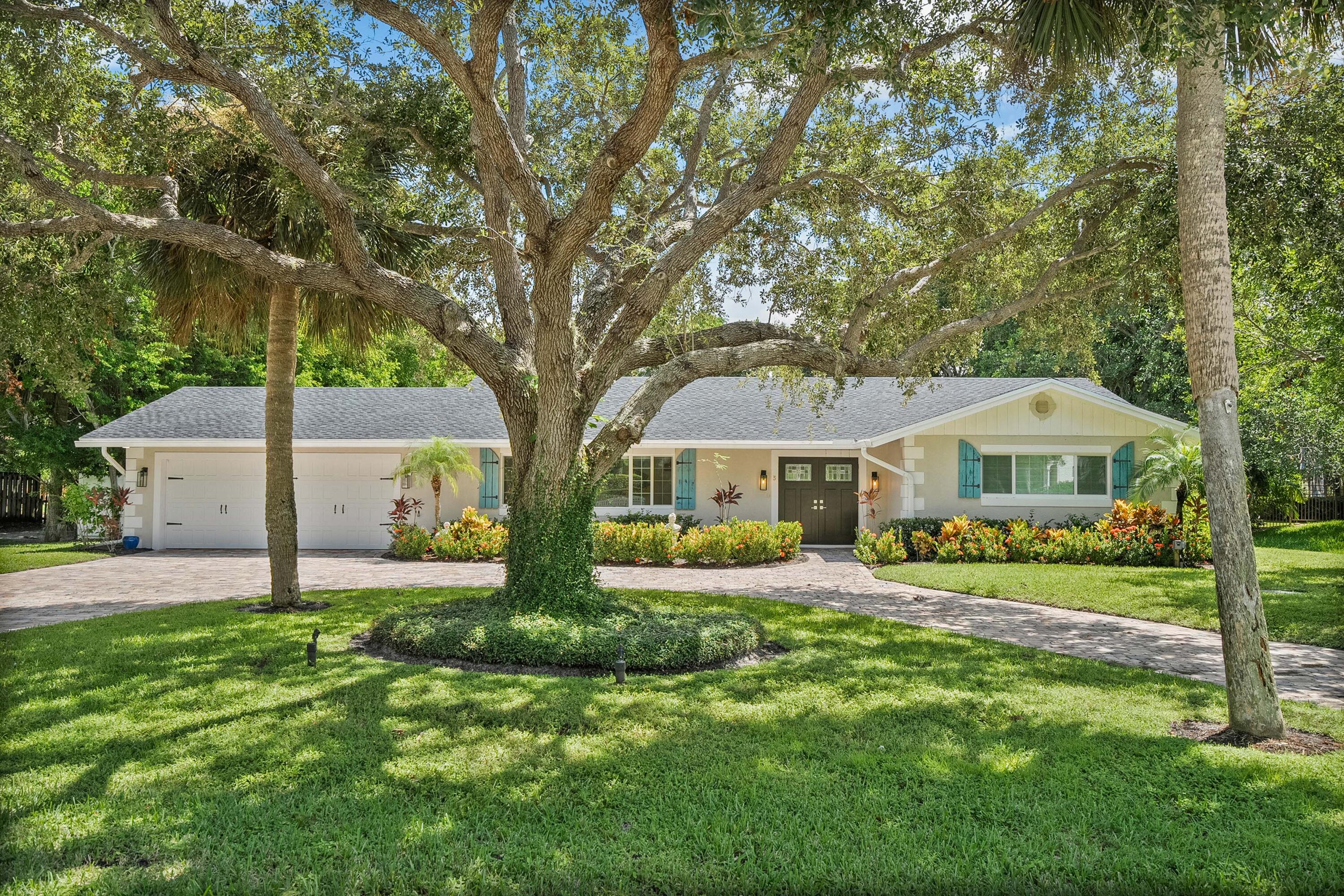 a front view of a house with a garden and trees