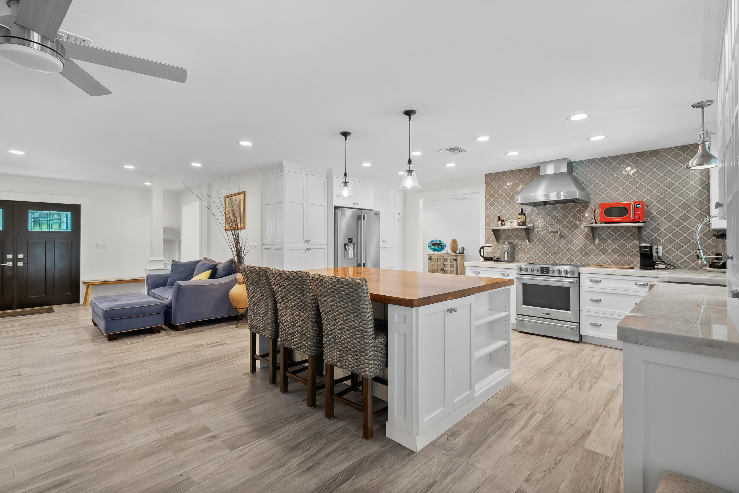 3 Mandalay Road Sewall's Point, FL 34996 - Photo 11 of 46 a kitchen with stainless steel appliances kitchen island granite countertop a stove a sink a refrigerator and white cabinets with wooden floor