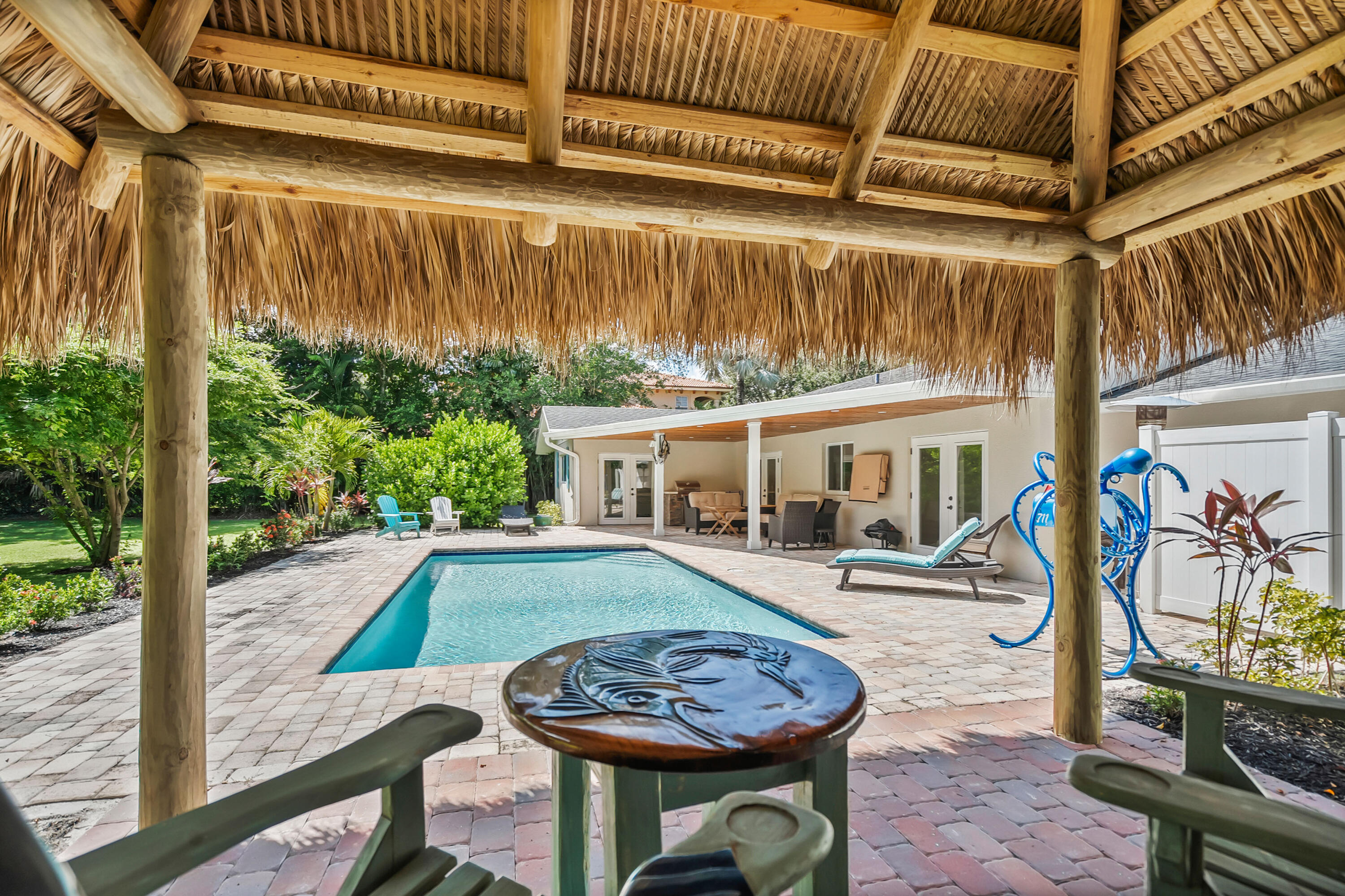 3 Mandalay Road Sewall's Point, FL 34996 - Photo 34 of 46 a view of a patio with table and chairs under an umbrella with a small yard