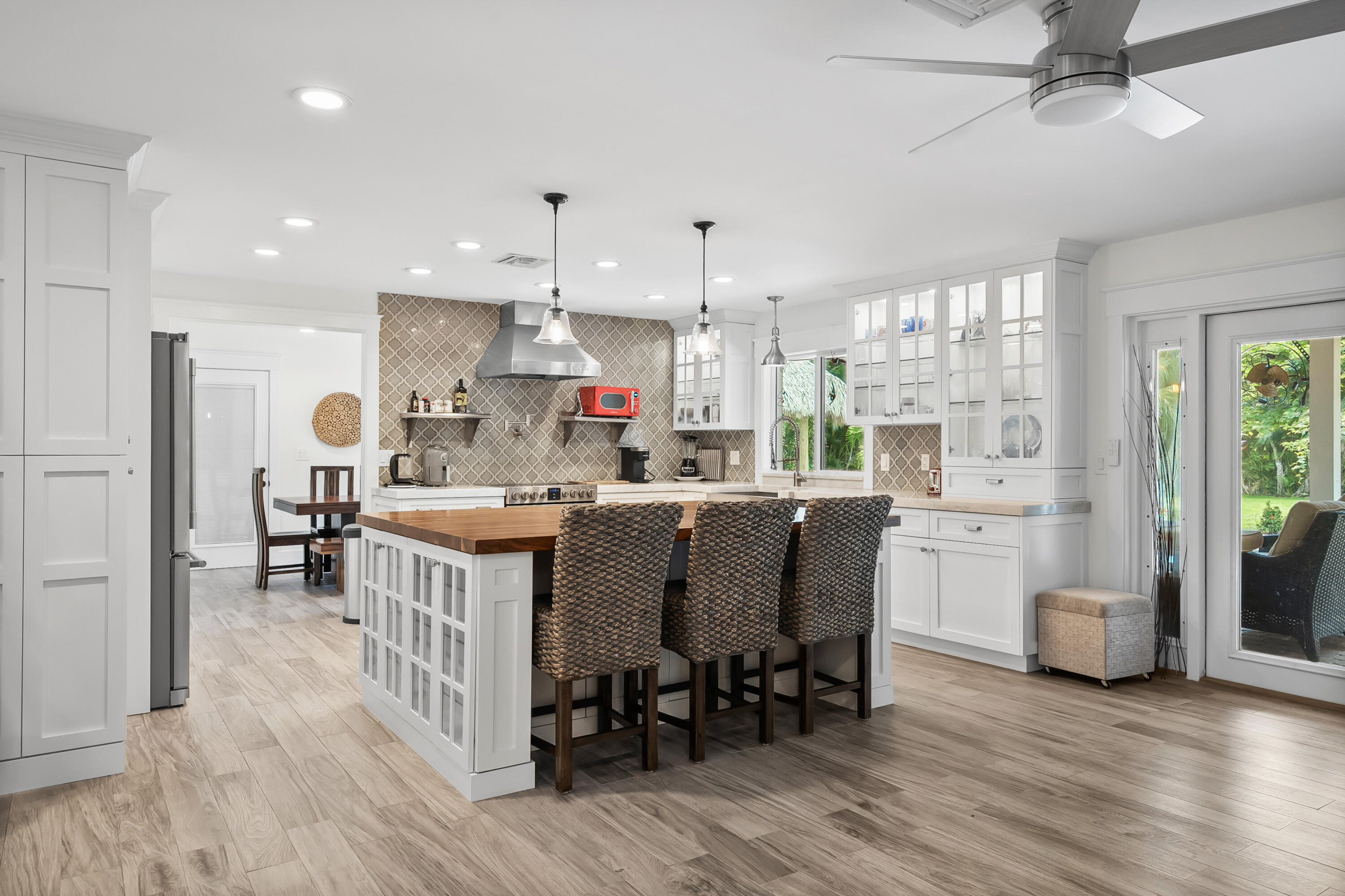 3 Mandalay Road Sewall's Point, FL 34996 - Photo 10 of 46 a kitchen with stainless steel appliances granite countertop a table chairs refrigerator and sink