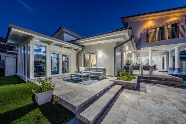 a view of a patio with couches table and chairs and potted plants