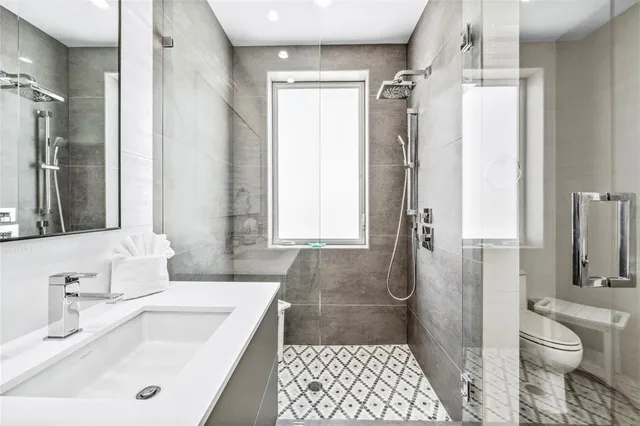 a bathroom with a sink a toilet and shower