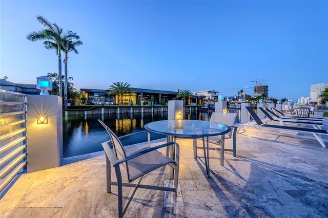 a view of a chairs and table in patio with swimming pool