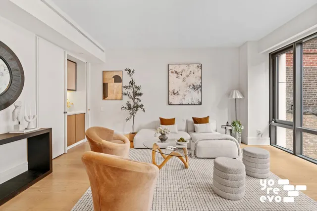 a living room with fireplace furniture and a potted plant