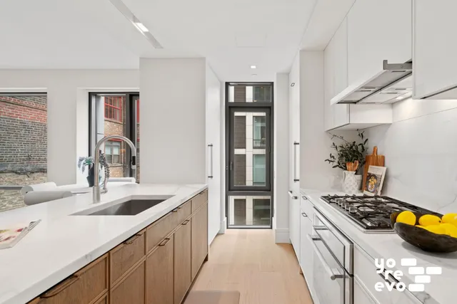a open kitchen with a sink a stove and white cabinets