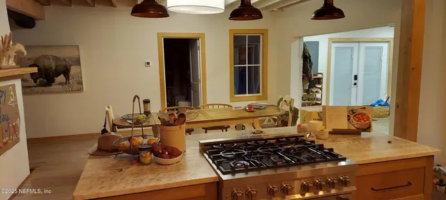 a kitchen with a stove and a wooden floor