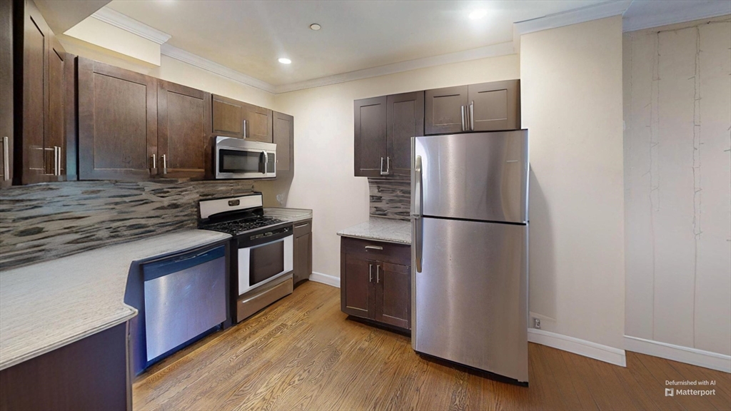 2975 Washington Street, Unit 2 Boston, MA 02119 - Photo 1 of 8 a kitchen with stainless steel appliances a refrigerator stove microwave and sink