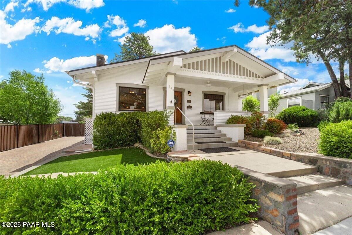 a view of a house with a yard and potted plants