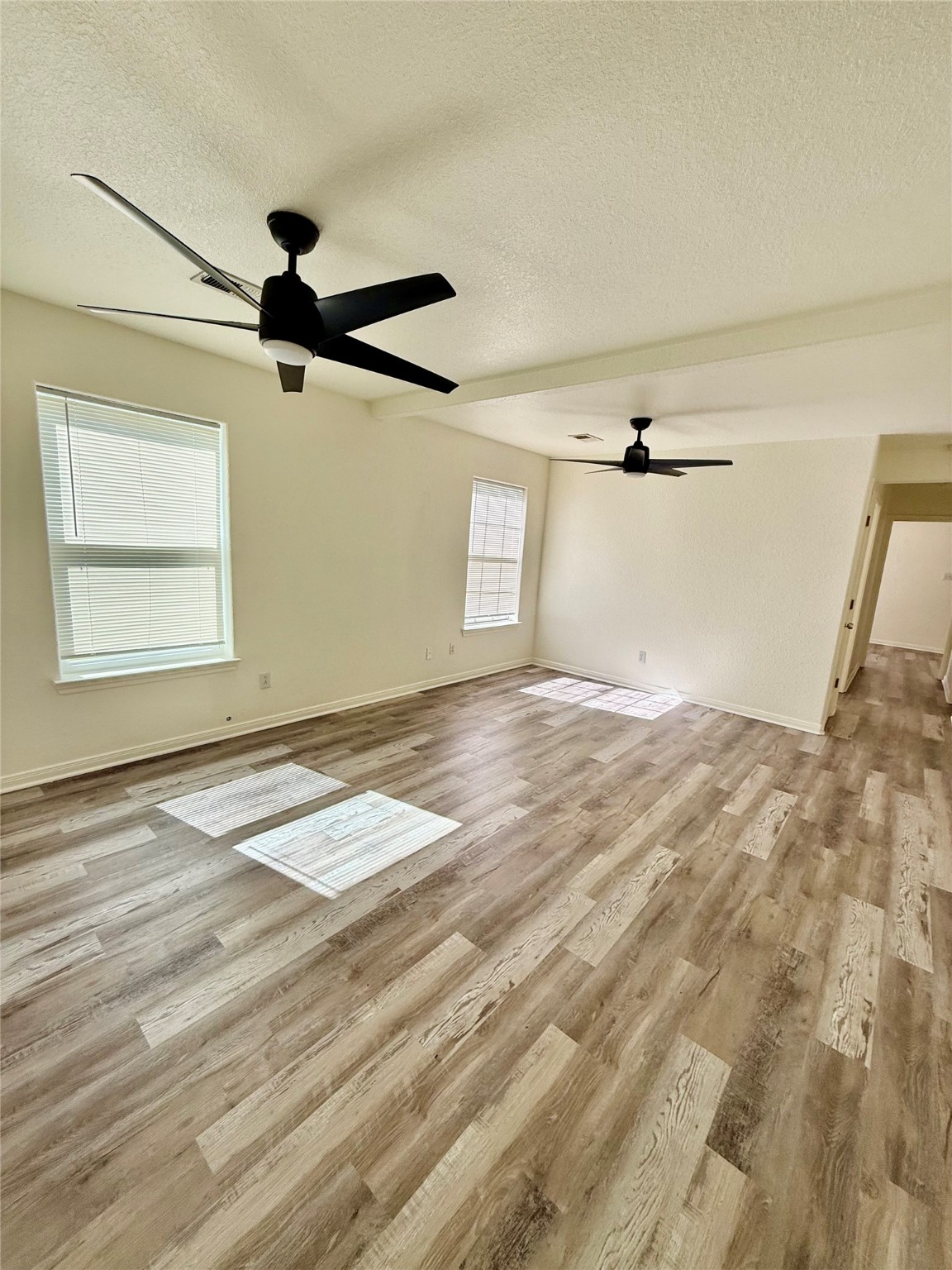 827 Algoa-Friendswood Road Alvin, TX 77511 - Photo 1 of 9 a view of empty room with wooden floor and fan